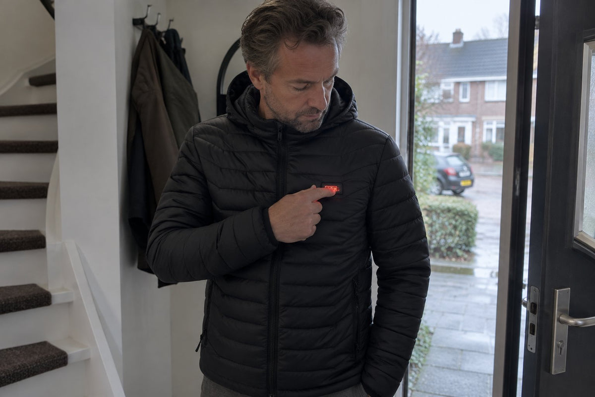 Man zet de verwarming van zijn jas aan bij de voordeur